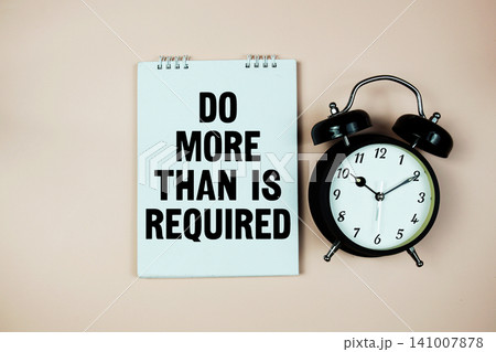 Motivational Message with Alarm Clock "Do More Than Is Required" on pink background 141007878