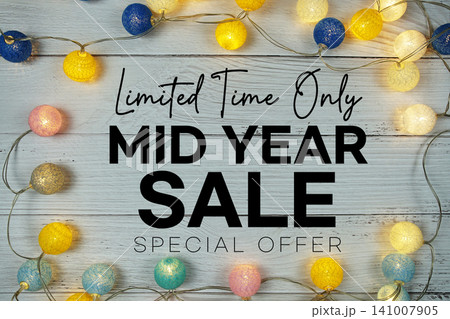 Mid Year Sale text with LED cotton balls decoration on wooden background Mid Year Sale text with LED cotton balls decoration on wooden background 141007905