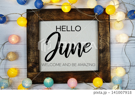 Hello June text with LED cotton ball decoration on wooden background 141007918