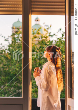 Woman Enjoying Quiet Morning Coffee On Balcony Woman Enjoying Quiet Morning Coffee On Balcony 141008496