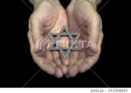 Jewish star of david in mature man hands over black background Jewish star of david in mature man hands over black background 141008685