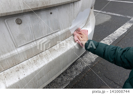 汚れた車のボディーを雑巾で水拭きしている 汚れた車のボディーを雑巾で水拭きしている 141008744