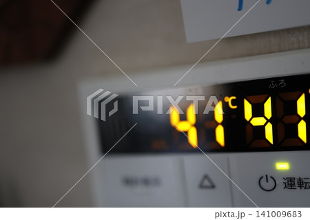 給湯器の液晶画面。給湯温度41度設定。黄色いデジタル表示。 給湯器の液晶画面。給湯温度41度設定。黄色いデジタル表示。 141009683