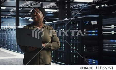 System administrator uses laptop in a server farm to plan disaster recovery and strengthen data protection. 141009794