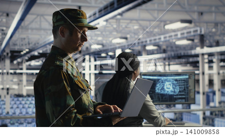 Army commander uses AI tools in a server room to manage secure military computer systems. 141009858
