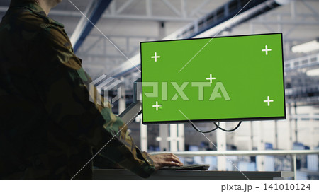 Military IT specialist reviews reconnaissance information on a green screen computer inside a server room. 141010124