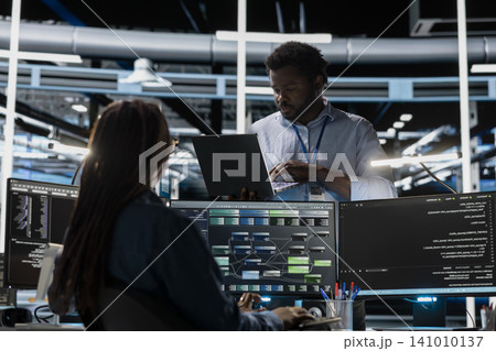 Computer scientist uses a PC in a data center to visualize interconnected AI neural networks and oversee information processing systems. Computer scientist uses a PC in a data center to visualize interconnected AI neural networks and oversee information processing systems. 141010137