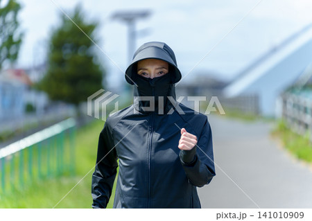 UVカットパーカーを着てジョギングをする女性 UVカットパーカーを着てジョギングをする女性 141010909