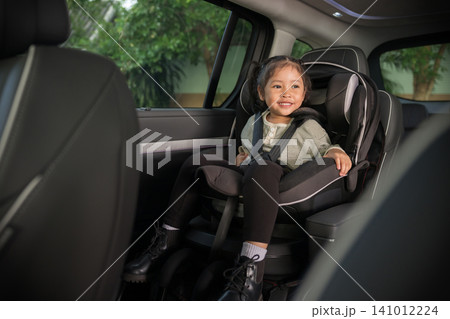 happy preschool child girl sitting in car seat, safety baby chair travelling happy preschool child girl sitting in car seat, safety baby chair travelling 141012224