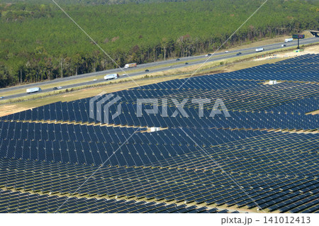 Aerial view of big sustainable electric power plant with many rows of solar photovoltaic panels for producing clean electrical energy. Renewable electricity with zero emission concept 141012413