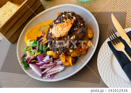 Pleskavitsa is fried minced cutlet with vegetable garnish 141012416