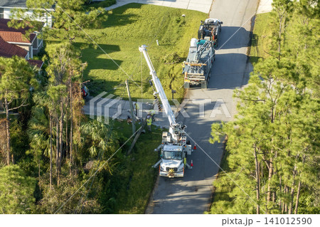 Electrical service company restoring power repairing damaged power lines after hurricane in Florida suburban area Electrical service company restoring power repairing damaged power lines after hurricane in Florida suburban area 141012590