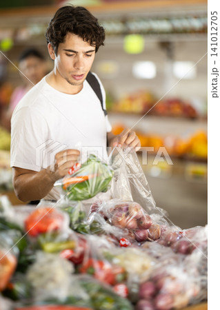 Man choose pick up vegetables in in plastic bags 141012705
