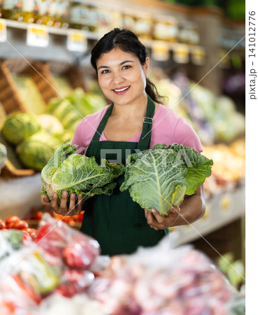 Woman worker seller in grocery vegetable shop assort fruit cabbage 141012776