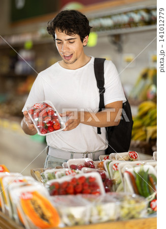 Male customer choosing vegetables and fruits in packaging at grocery store Male customer choosing vegetables and fruits in packaging at grocery store 141012779
