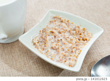 Buckwheat porridge with milk in bowl closeup Buckwheat porridge with milk in bowl closeup 141012823