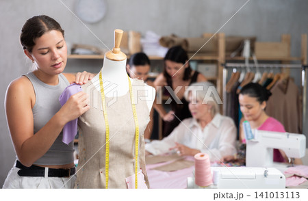 Young woman working with mannequin during master class 141013113