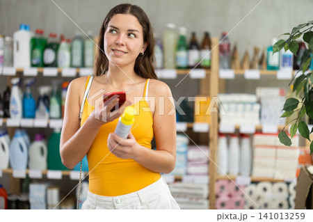 Girl buyer scans qr code on mosquito repellent label 141013259
