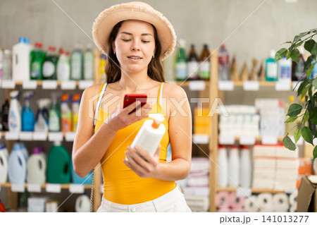 Woman scans a mobile barcode of a package of sunscreen products Woman scans a mobile barcode of a package of sunscreen products 141013277
