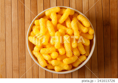 Top view of golden corn sticks in a bowl on a bamboo surface Top view of golden corn sticks in a bowl on a bamboo surface 141013726
