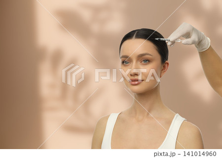 Woman with smooth skin receiving facial injection calmly Woman with smooth skin receiving facial injection calmly 141014960