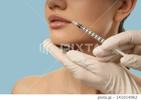 A healthcare expert performs a lip enhancement treatment 141014962