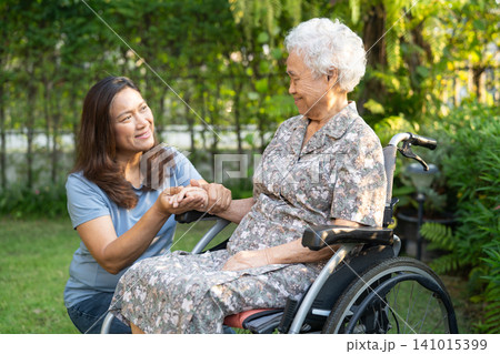 Caregiver help and care Asian senior woman patient sitting on wheelchair at nursing hospital ward, healthy strong medical. Caregiver help and care Asian senior woman patient sitting on wheelchair at nursing hospital ward, healthy strong medical. 141015399