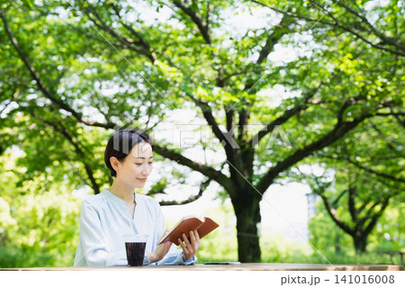 屋外で読書をする若い女性　ライフスタイルイメージ 141016008