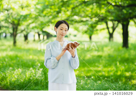 屋外で読書をする若い女性 ライフスタイルイメージ 屋外で読書をする若い女性 ライフスタイルイメージ 141016029