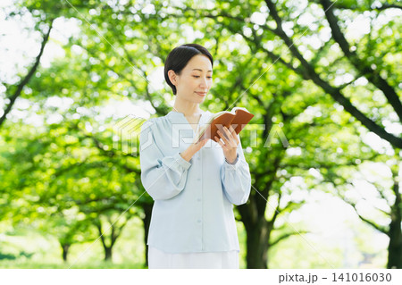 屋外で読書をする若い女性 ライフスタイルイメージ 屋外で読書をする若い女性 ライフスタイルイメージ 141016030