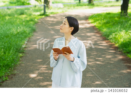 屋外で読書をする若い女性 ライフスタイルイメージ 屋外で読書をする若い女性 ライフスタイルイメージ 141016032