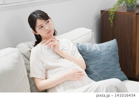 ソファーでくつろいでいる妊婦 ライフスタイルイメージ ソファーでくつろいでいる妊婦 ライフスタイルイメージ 141016434
