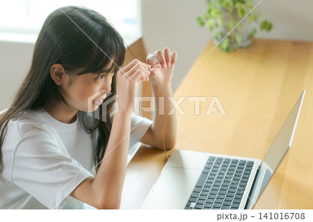 退屈そうにオンライン授業を受ける女の子 退屈そうにオンライン授業を受ける女の子 141016708