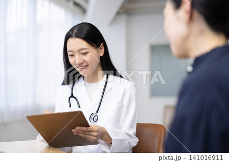 患者を診察する若い日本人の女性医師 141016911