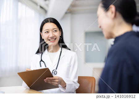 患者を診察する若い日本人の女性医師 141016912