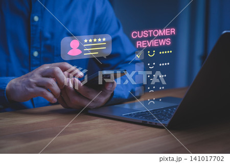 Man using smartphone for online customer review. Five star rating and satisfaction feedback concept for business service quality and digital experience. Man using smartphone for online customer review. Five star rating and satisfaction feedback concept for business service quality and digital experience. 141017702