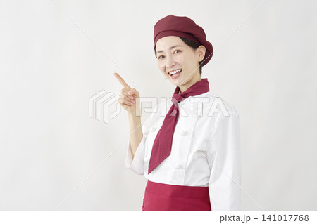 左側を指差すパティシエ女性 141017768
