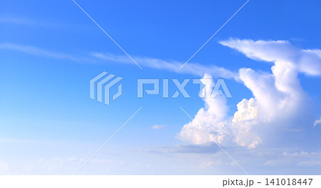 White clouds in the blue sky. Beautiful nature landscape. The azure expanse of the sky is adorned with pristine white clouds, creating a picturesque natural scene 141018447