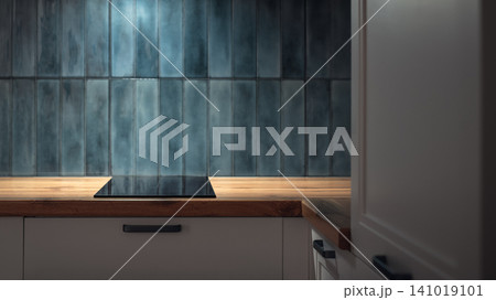 Modern kitchen countertop with induction cooktop and blue ceramic tile backsplash Modern kitchen countertop with induction cooktop and blue ceramic tile backsplash 141019101