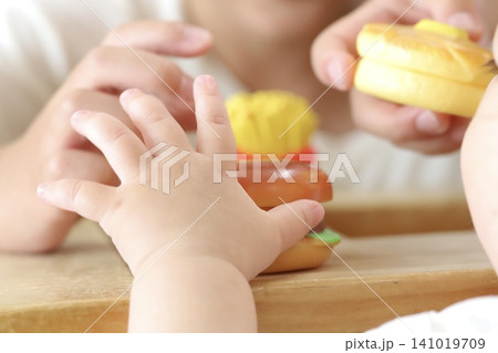 おもちゃで遊ぶ赤ちゃんと子供の手 おもちゃで遊ぶ赤ちゃんと子供の手 141019709