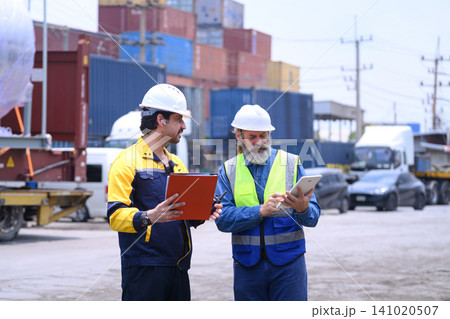 Shipping supervisors discussing freight container management at commercial logistics terminal. 141020507