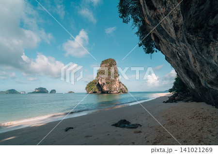 Beautiful view of a limestone karst island from a sandy beach under an overhanging cliff in Krabi, Thailand. 141021269