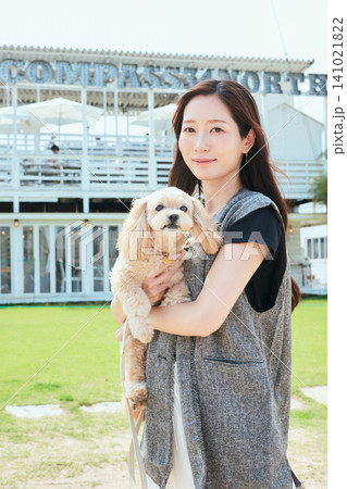 愛犬のトイプードルを抱いて微笑む若い女性 愛犬のトイプードルを抱いて微笑む若い女性 141021822