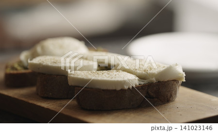 making bruschetta with pesto and mozzarella making bruschetta with pesto and mozzarella 141023146