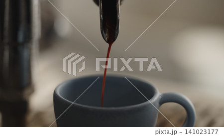 closeup espresso pour in ceramic cup 141023177