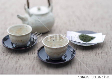 緑茶を淹れた湯呑みが並ぶ和の茶時間、茶葉とティーポット 緑茶を淹れた湯呑みが並ぶ和の茶時間、茶葉とティーポット 141023196