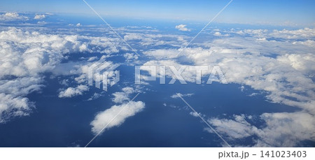 clouds and sky as seen through window of an airplane clouds and sky as seen through window of an airplane 141023403