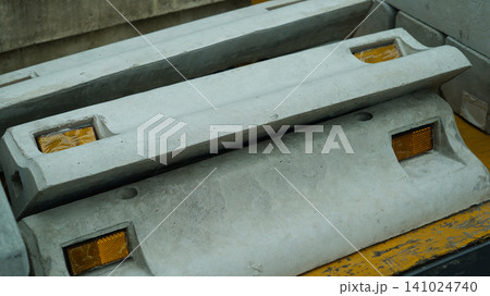 Concrete wheel stoppers with yellow reflectors close up Concrete wheel stoppers with yellow reflectors close up 141024740