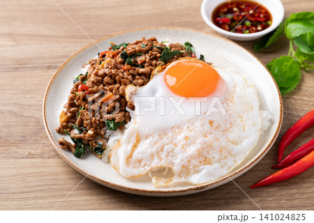 Thai food, Stir-fried holy basil with minced pork with cooked rice and fried egg on top Thai food, Stir-fried holy basil with minced pork with cooked rice and fried egg on top 141024825