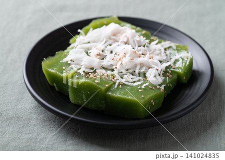 Traditional Thai dessert, pandan sweet pudding topped with coconut and toasted sesame seeds Traditional Thai dessert, pandan sweet pudding topped with coconut and toasted sesame seeds 141024835